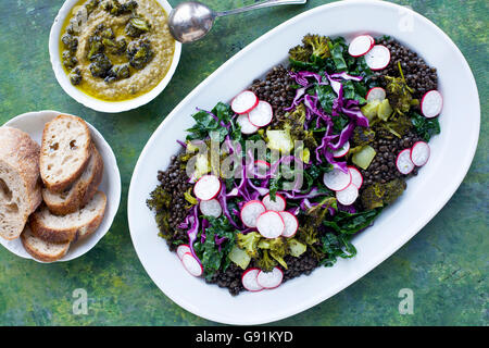 Lentilles noires Salade de brocoli Chou Brocoli carbonisés avec le pesto. Sur un vert, jaune et le fond bleu. Photographié en vue de dessus Banque D'Images