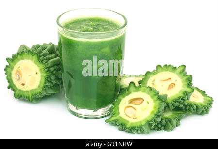 Jus d'herbes d'momodica vert dans un verre avec des tranches de légumes Banque D'Images