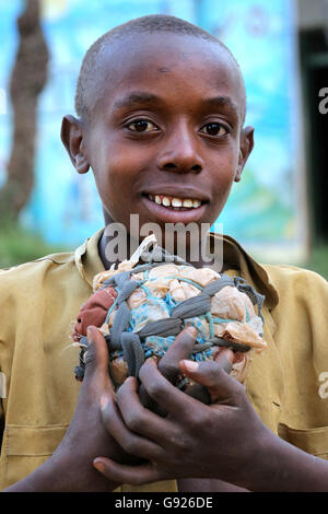 Jeune garçon (12 ans) avec son football self-made en tissu et les restes de sacs en plastique dans un village près de Ruhengeri, Rwanda, Afrique du Sud Banque D'Images