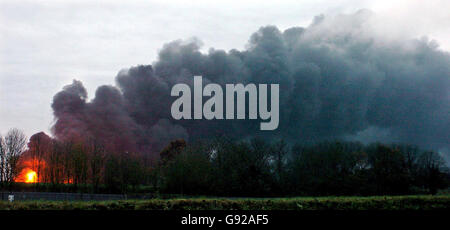 De la fumée et des flammes s'élèvent lundi 12 décembre 2005 depuis le dépôt de pétrole de Buncefield près de Hemel Hemsptead, où les pompiers ont été mis en route pour s'attaquer à l'incendie massif qui a commencé tôt dimanche matin.Les pompiers ont passé hier à contenir le feu avec un « rideau d'eau » entre les flammes qui font rage et les sept réservoirs de carburant non explosés et ont maintenant rassemblé assez d'équipement de tout le pays pour étouffer le feu avec de la mousse.Voir PA Story BLASTE explosion.APPUYEZ SUR ASSOCIATION photo.Crédit photo devrait lire: Chris Radburn / PA. Banque D'Images