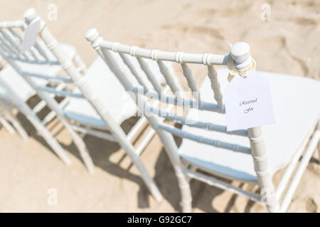 Des chaises disposés sur la plage de sable blanc pour mariage, réservés, selective focus Banque D'Images