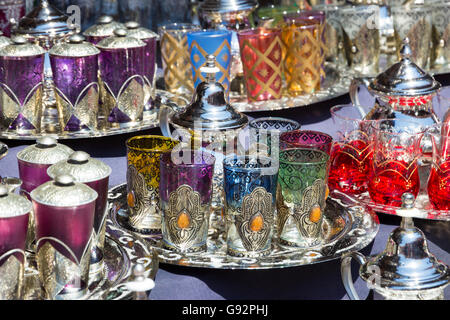 Théières traditionnelles avec des verres à thé sur un plateau vendus dans les souks de Marrakech, Maroc Banque D'Images