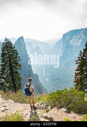 Jeune homme sur sentier de randonnée, vue sur la vallée Yosemite, quatre Mile Trail, le Taft Point, El Capitan, Yosemite National Park, Californie Banque D'Images