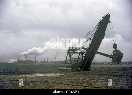 La digger sur l'EarlTree Direction générale de l'ironstone, Corby, avec Corby Iron and Steel Works en arrière-plan. Banque D'Images