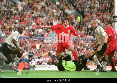 Robbie Fowler de Liverpool (au centre) braque le ballon au-delà de Charlton Gardien de but sportif Sasa Ilic (sur le sol) pour marquer son deuxième but Banque D'Images