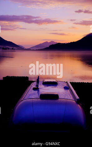 Coucher de soleil sur le Loch Leven avec caravane Airstream en premier plan à Invercoe, Glencoe, Ballachlish, Argyll, Scotland, UK. Banque D'Images