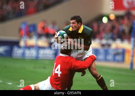 Le Joost Van Der Westhuizen (à droite) d'Afrique du Sud est abordé par Gareth Thomas, pays de Galles (gauche) Banque D'Images