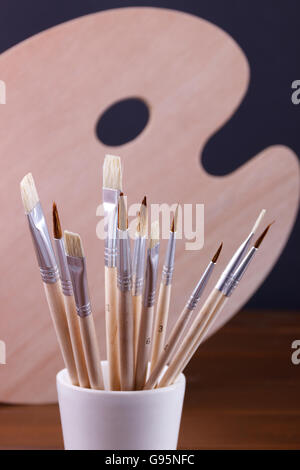Ensemble de brosses de peinture et nettoyer la palette à bureau en bois. Concept.Vertical Banque D'Images
