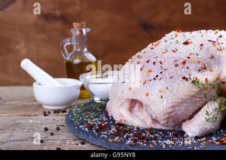 Ensemble le poulet cru avec du citron, le thym, le paprika et l'assaisonnement épices sur pierre noire à découper.selective focus Banque D'Images