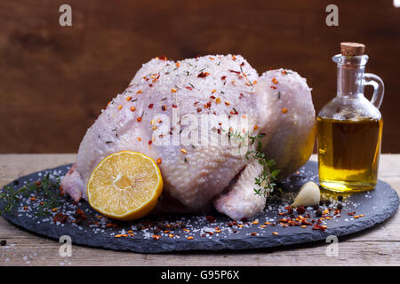 Ensemble le poulet cru avec du citron, le thym, le paprika et l'assaisonnement épices sur pierre noire à découper.selective focus Banque D'Images