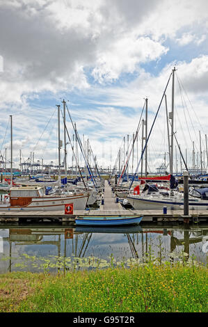 Yachts amarrés dans Shotley Marina, Suffolk, UK avec Felixstowe port à conteneurs à l'arrière-plan Banque D'Images