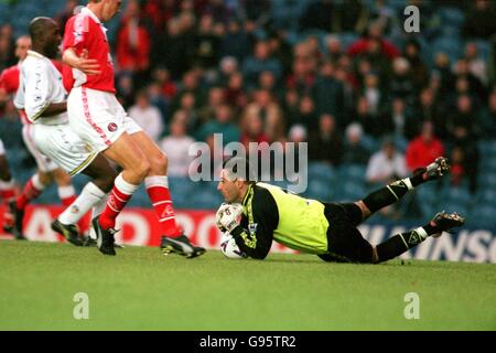 Charlton Athletic Goalkeeper Sasa Ilic (à droite) fume le ballon à Les pieds du coéquipier Carl Tiler (au centre) Banque D'Images