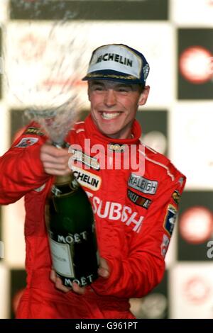 Richard Burns, de l'Angleterre, pulvérise du champagne pour célébrer la victoire du Rallye de Grande-Bretagne, sur le podium à Cheltenham Banque D'Images