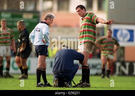 Rugby Union - Allied Dunbar Premiership - Leicester v Wasps.Martin Johnson de Leicester (à droite) fait un point pour l'arbitre Ed Morrison (à gauche) tandis que le physio le traite pour un genou blessé Banque D'Images