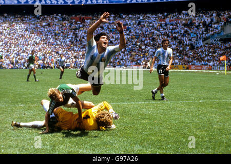 Football - coupe du monde Mexique 1986 - finale - Argentine contre Allemagne de l'Ouest.Diego Maradona (en haut) en Argentine vole dans les airs après un défi lancé par le gardien de but de l'Allemagne de l'Ouest Harald Schumacher (au sol) Banque D'Images