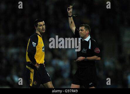 Paul Scharner de Wigan Athletic est réservé par l'arbitre Phil Dowd Banque D'Images