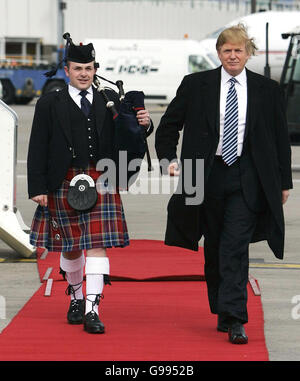 Visite de Donald Trump en Écosse.Le magnat AMÉRICAIN des affaires Donald Trump marche avec le joueur de cornemuse Andrew Macleod après son arrivée à l'aéroport d'Aberdeen, en Écosse. Banque D'Images