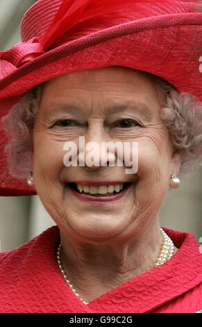 La reine Elizabeth II de Grande-Bretagne passe un cadeau d'une casquette de baseball de syndicat Jack à un assistant lors d'une promenade pour célébrer son 80e anniversaire à Windsor. Banque D'Images