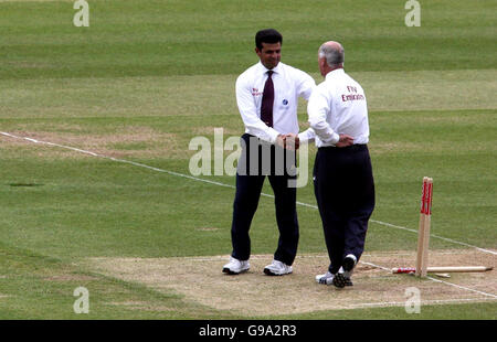 Les arbitres Aleem Dar (L) et Rudi Koertzen abandonnent officiellement le match en raison de la mauvaise lumière le dernier jour du premier match du npower Test au terrain de cricket de Lord, Londres. Banque D'Images