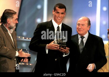 Rivaldo, du Brésil et de Barcelone (c), reçoit à Bruxelles le trophée du joueur mondial de l'année de la FIFA, décerné par le président de la FIFA, Joseph Sepp Blatter (r), sous la direction de George Best (l), qui a reçu le prix des gagnants suivants de David Beckham Banque D'Images