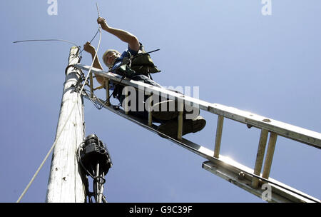 Stock photo générique de British Telecom - BT - les ingénieurs au travail en éliminant l'ancien telecom ou les poteaux de téléphone et d'un remplacement de câbles téléphoniques dans la région de la vallée de Carron près de Stirling, Écosse. Banque D'Images