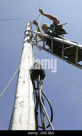 Stock photo générique de British Telecom - BT - les ingénieurs au travail en éliminant l'ancien telecom ou les poteaux de téléphone et d'un remplacement de câbles téléphoniques dans la région de la vallée de Carron près de Stirling, Écosse. Banque D'Images