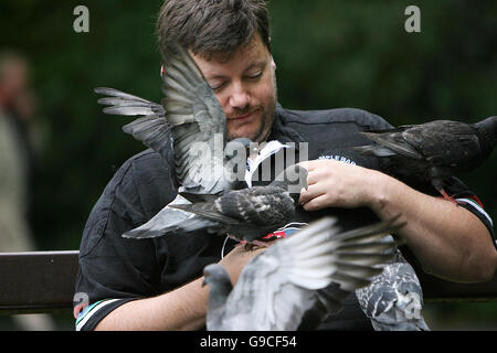 Un homme est couvert par les pigeons comme il les nourrit à St Stephen's Green à Dublin. Banque D'Images