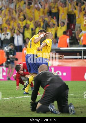 Football - coupe du monde de la FIFA 2006 Allemagne - Groupe B - Suède / Angleterre - RheinEnergieStadion.Jamie Carragher et Paul Robinson, en Angleterre, ont l'air abattu tandis que Henrik Larsson, en Suède, célèbre son dernier égalisateur Banque D'Images