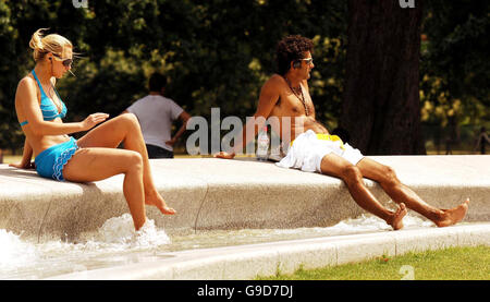 Les visiteurs se rafraîchissez dans la fontaine commémorative de la princesse Diana, à Hyde Park, dans le centre de Londres. Banque D'Images