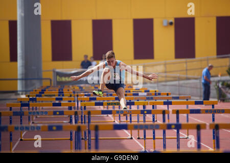 Boy doing sports athlétiques sauts sur une piste Banque D'Images