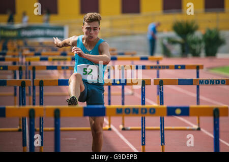 Boy doing sports athlétiques sauts sur une piste Banque D'Images