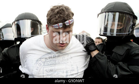 Un fan de football d'Angleterre est conduit par la police alors que les fans d'Angleterre et d'Allemagne s'affrontent sur la Schlossplatz à Stuttgart, en Allemagne, où des milliers de fans anglais et allemands sans billet regardaient le match Allemagne-Suède sur grand écran. Banque D'Images