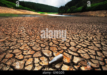 Comme la longue période chaude se poursuit, des réservoirs comme le réservoir Howden, au sommet de la vallée Derwent dans le district de Peak, commencent à présenter des fissures dans la boue. Banque D'Images