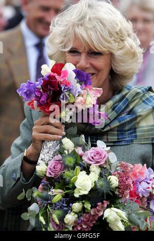 La duchesse de Cornwall reçoit un bouquet de fleurs lorsqu'elle arrive aux jeux de Mey Highland à Caithness. Banque D'Images