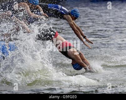 Les participants du Male Elite Catergory plongent dans les Royal Victoria Docks avant le début du triathlon du 10e anniversaire de Londres à Londres. Banque D'Images