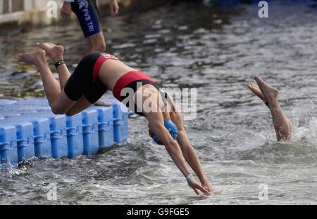 Les participants de la « Cathédrale élite » plongent dans le Royal Victoria Dock, avant le début du triathlon de Michelob ULTRA London à Londres. Banque D'Images