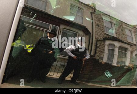 Les policiers à l'extérieur d'une maison à Albert Road, Walthamstow, dans l'est de Londres, sont reflétés dans une fenêtre de voiture. Banque D'Images