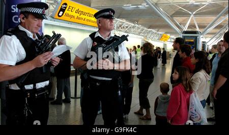 La police armée patrouille le salon de l'aéroport de Londres Stansted à Essex, Les passagers étaient confrontés à des retards suite au journal des vols annulés et retardés après une importante opération de sécurité qui a conduit à 24 arrestations dans tout le Royaume-Uni dans le cadre d'un présumé complot visant à faire exploser des avions de passagers en quittant les aéroports britanniques pour les États-Unis. Banque D'Images