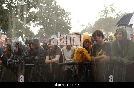 Fans de musique imprégnés de pluie au V Festival à Hylands Park à Chelmsford, Essex. Banque D'Images