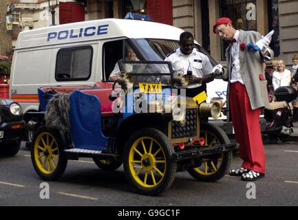 Le clown de cirque « Polo » se retrouve en train de discuter avec un policier de son espace dans la station de taxis, devant la fête organisée pour célébrer la publication des Confessions d'un showman de Gerry Cottle, au Theatre Museum, à Covent Garden, dans le centre de Londres. Banque D'Images