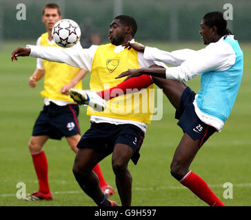 Le Kolo Toure d'Arsenal (à gauche) est défié par le coéquipier Emmanuel Adebayor lors d'une session d'entraînement à Londres Colney, Hertfordshire. Banque D'Images