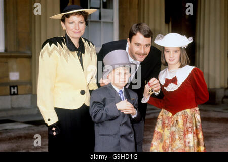 Nigel Mansell, chauffeur de Formule 1, montre son OBE devant Buckingham Palace, avec l'aide de sa femme Roseanne et de leurs enfants Leo et Chloe Banque D'Images