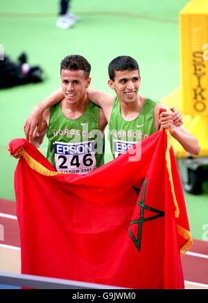 Athlétisme - Championnat du monde en salle de l'IAAF 2001 - Lisbonne.Le Maroc Said Berioui (l) et Hicham El Guerrouj (r) détiennent en altitude le drapeau marocain après la finale de 3000m Banque D'Images