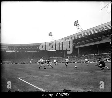 Geoff Hurst de West Ham United (deuxième l) Tire dans une balle au gardien de but de Preston North End Alan Kelly (r) Banque D'Images