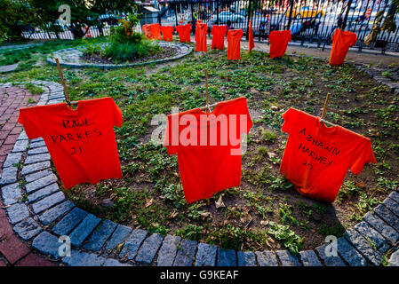 New York, USA 29 juin 2016 dans le cadre du Mois de sensibilisation à la violence des armes à feu les bénévoles Orange t-shirts plantés dans la cour de St Mark's Church dans le Bowery qui portent les noms des victimes de la violence armée ©Stacy Walsh Rosenstock Banque D'Images