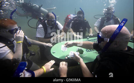 Les joueurs de poker sous-marins se disputent sur la table de finale, le 28 novembre, lors du tournoi de poker sous-marin extrême, qui se tient au large de la côte de l'île de Saint-Kitts dans les Caraïbes. Banque D'Images