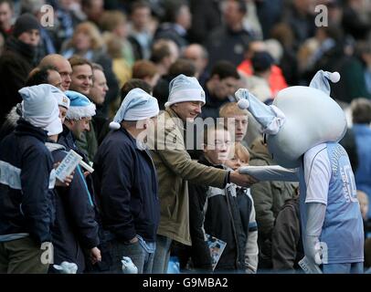 La mascotte Blue Moon de Manchester City secoue les mains avec les fans avant le jeu Banque D'Images