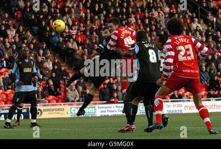 Paul Heffernan de Doncaster (au centre) saute clairement pour marquer le but égalisateur lors du match One contre Rotherham de la Coca Cola football League, au Keepmoat Stadium, Doncaster. Banque D'Images