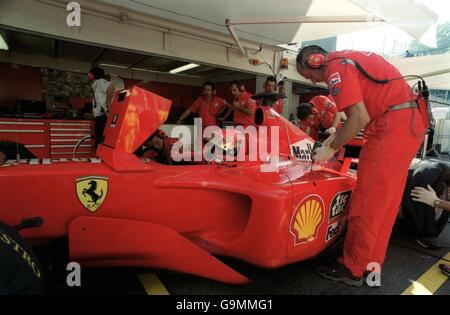 Course automobile Formula One - Grand Prix de Monaco - qualification.Michael Schumacher montre se qualifier sur son moniteur pendant que l'équipe Ferrari travaille sur sa voiture Banque D'Images