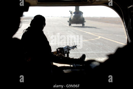 Un charmeur regarde un hélicoptère Chinook de la RAF lorsqu'il départ à la base aérienne de Kandahar, en Afghanistan. Banque D'Images